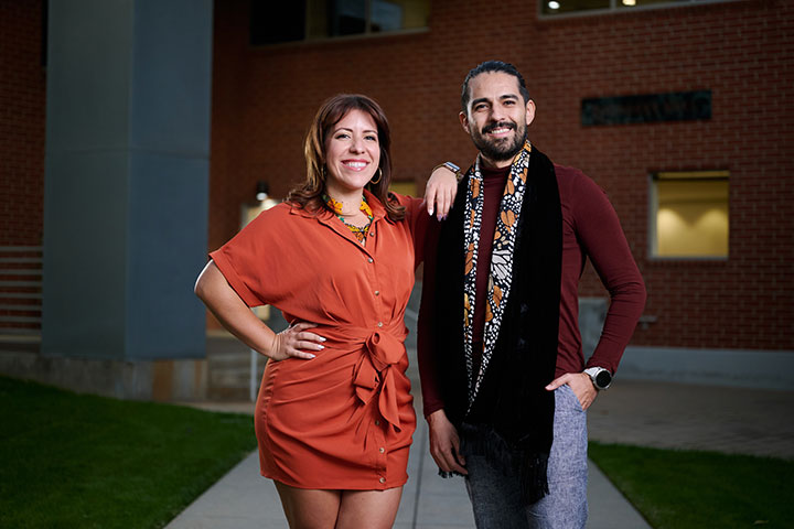 Two individuals in professional attire at the LMU Loyola Law School campus in the evening