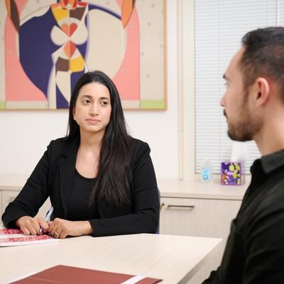 Amal Sardesai speaking to a colleague at a desk