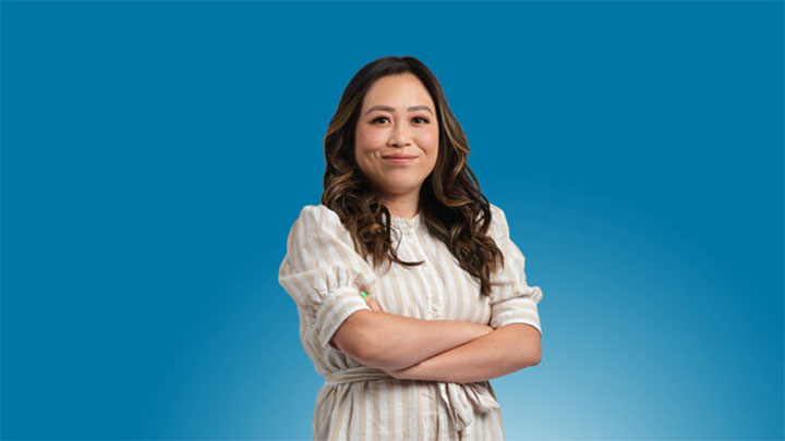 A person with arms folded looking into the camera