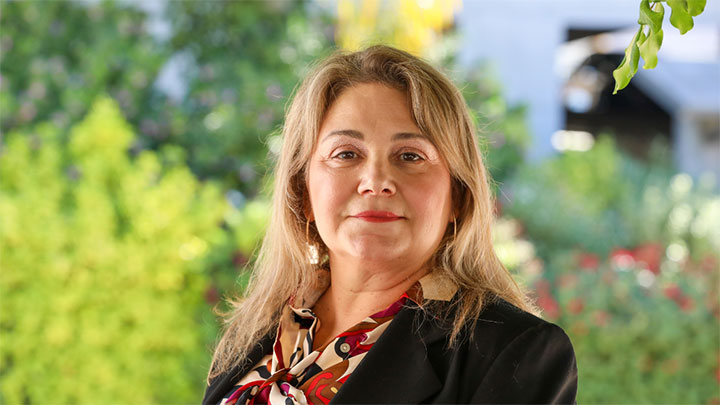 A person in professional attire looking into the camera