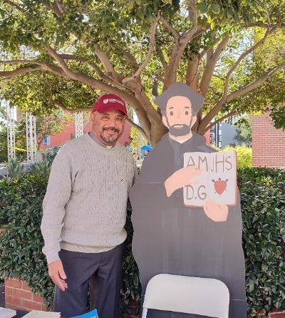 Chaplain standing with poster of Ignatius